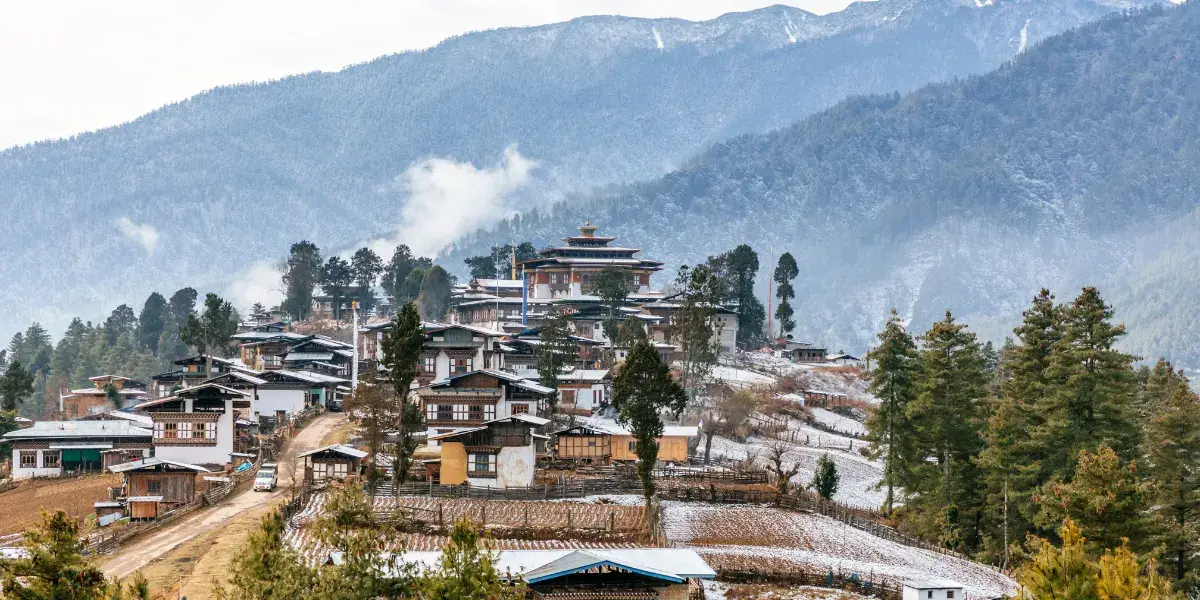 Gangtey Monastery overlooking a snow-dusted village and pine forests in the glacial Phobjikha Valley Bhutan