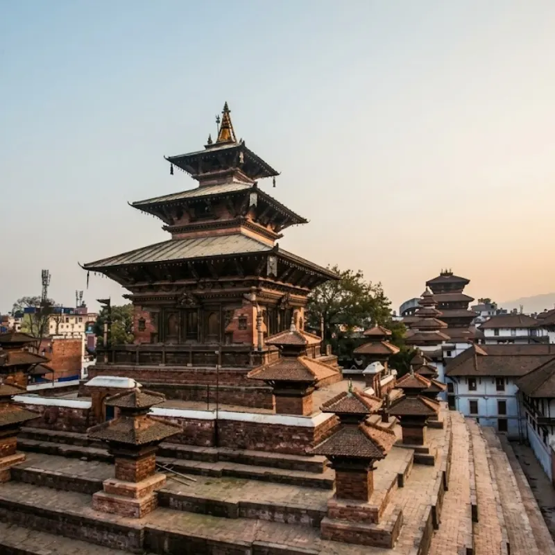 Multi-tiered Newari wooden pagoda temple with stepped brick plinth in Patan Durbar Square Nepal.